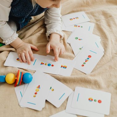 A child playing with educational cards and colorful toys, promoting cognitive skills and creativity.